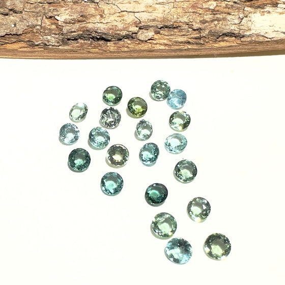 This parcel of 21 round cuts of natural unheated tourmaline ranges from light green to pale teal blue to mid green blue.&nbsp;