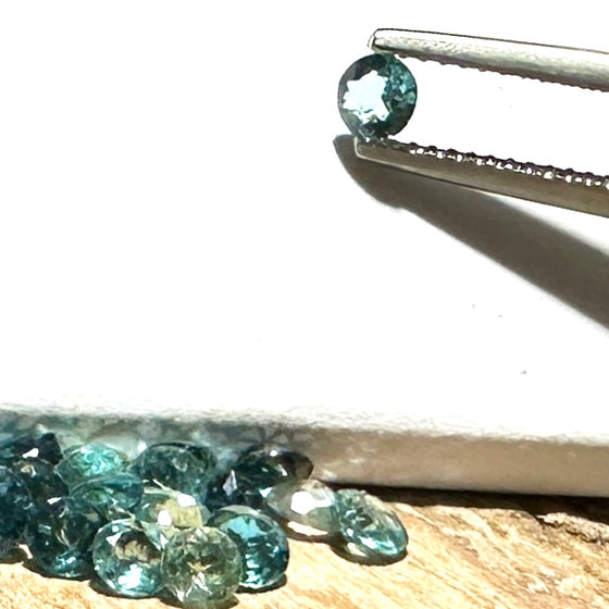 This parcel of 27 round cuts of natural unheated tourmaline ranges from light green to pale teal blue.&nbsp; They are all eye clean. The depth varies.