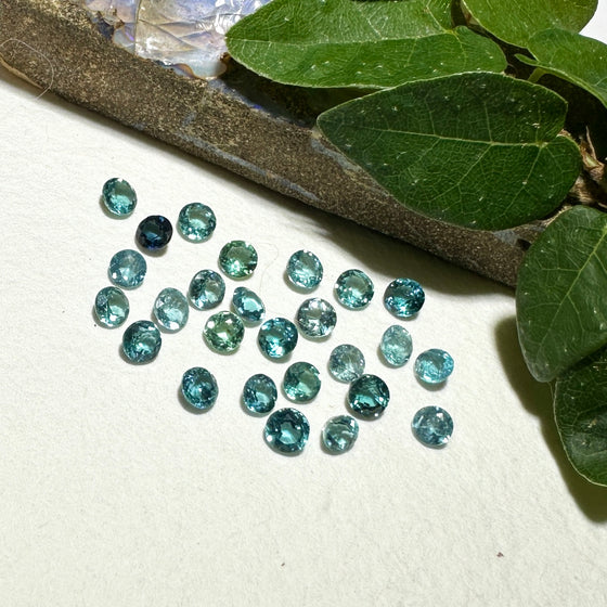 This parcel of 27 round cuts of natural unheated tourmaline ranges from light green to pale teal blue.&nbsp; They are all eye clean. The depth varies.