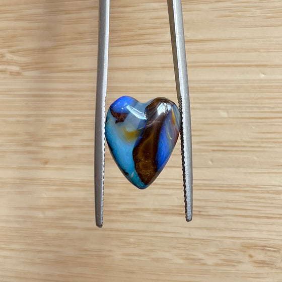 8.75ct Heart Shape Boulder Opal, this heart has swirling patterns of dark blue, light blue gold and brown, the colour is also on the sides making it a perfect pendant piece.