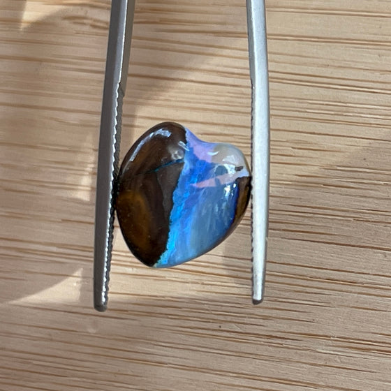 5.4ct Heart Shape Boulder Opal, it has been cut and polished leaving a line down the centre and bright blue on the other. The back also has interesting patterns, so this could be used as a double sided pendant.