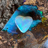 2.05 heart shaped crystal opal, this small bright heart has bright flashes of green, there is a darker line on one side.