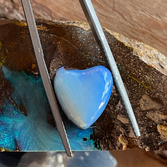 7.35ct Heart Shape Boulder Opal with clear blue green softly swirling patterns on the surface, the colour goes around the side as well. 