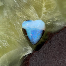  5ct Heart Shape Boulder Opal, this tiny heart is clear misty blue across the top with a slightly darker blue at the base. The cutter has used the patterns in the opal to enhance the piece.