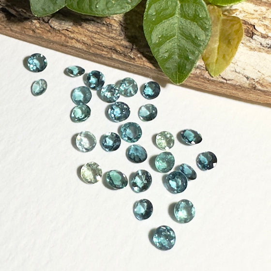 This parcel of 27 round cuts of natural unheated tourmaline ranges from light green to pale teal blue.&nbsp; They are all eye clean. The depth varies.