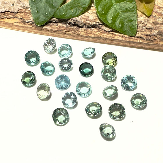 This parcel of 21 round cuts of natural unheated tourmaline ranges from light green to pale teal blue to mid green blue.&nbsp;