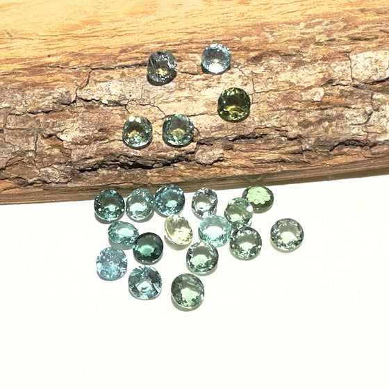 This parcel of 21 round cuts of natural unheated tourmaline ranges from light green to pale teal blue to mid green blue.&nbsp;
