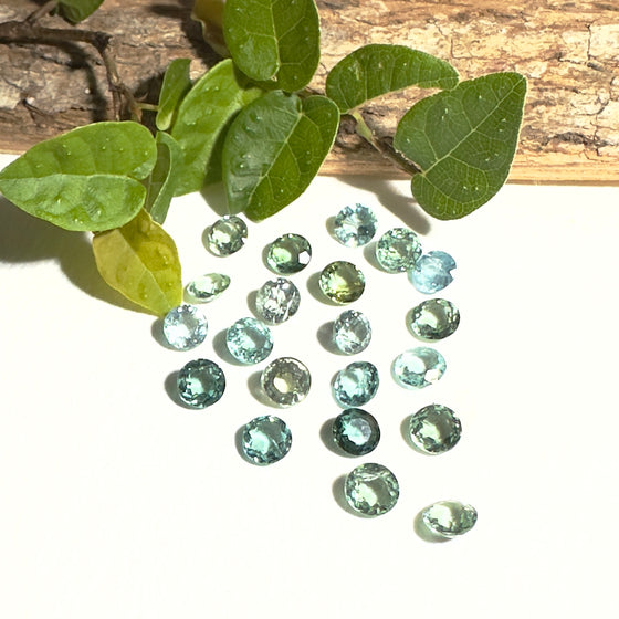 This parcel of 21 round cuts of natural unheated tourmaline ranges from light green to pale teal blue to mid green blue.&nbsp;