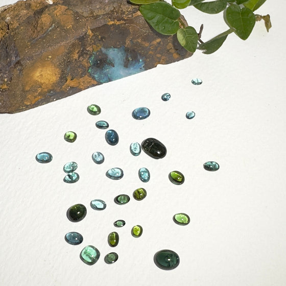 This parcel of 30 pieces of natural unheated tourmaline ranges from light teal blue to mid green to dark teal. They are all eye clean and assorted size cabochon cut.