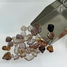  This Australian Zircon Rough has a mixture of pale pinkish, yellowish and near colourless stones. Most are lightly to moderately included. These have not been treated in any way other than being tumbled.